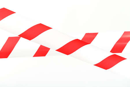 A tape with red and white stripes for the barrier prohibits passage. Barrier tape on a white backgroundの写真素材