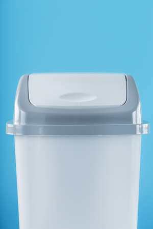 White trash can on a light blue background with free space. Cleanliness, order and segregated waste collection conceptの写真素材