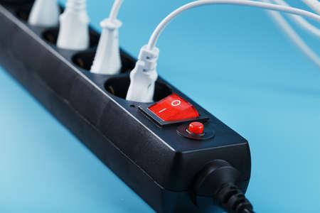 Surge protector with connected white wires of electrical appliances on a blue background. Free spaceの写真素材