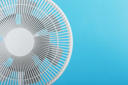 Electric fan in white with a modern design for cooling the room on a blue background. Free space, minimalistic style.の写真素材