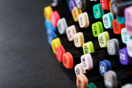 A set of markers for drawing in different colors for sketching with markings in a bag on a black background. Free spaceの写真素材