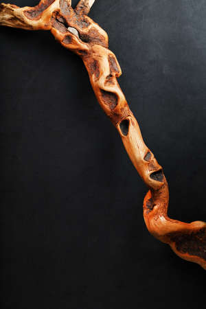 Textured curved Wooden snag of brown color with texture on a black background with free space.の写真素材