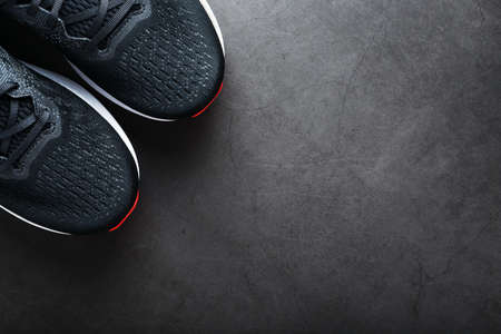 Black sports sneakers with red soles on a black background. Free spaceの写真素材
