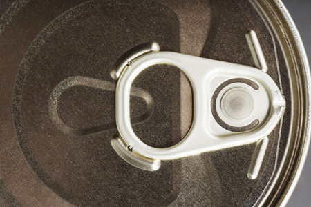 The lid of a metal tin can on a black background. top view, close-up