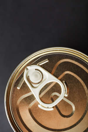 The lid of a metal tin can on a black background. top view, close-upの写真素材