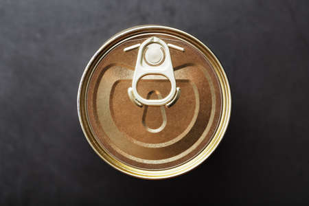 The lid of a metal tin can on a black background. top viewの写真素材