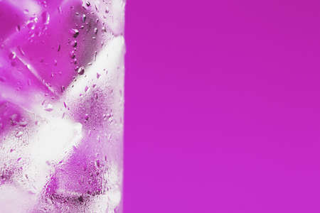 Ice cubes in a glass with crystal clear water on a blue background. Refreshing and healthy water on hot days Soft Selective Focusの写真素材