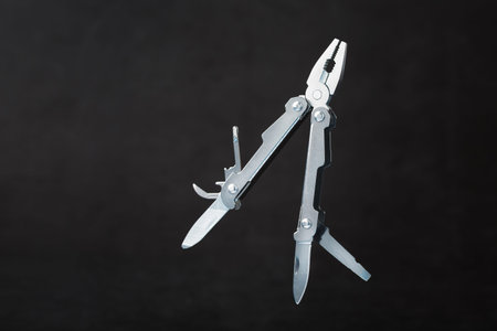Multi-functional tool on a black textural background. free space