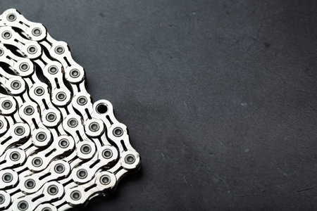 Silver chain of a road bike on a dark textured background