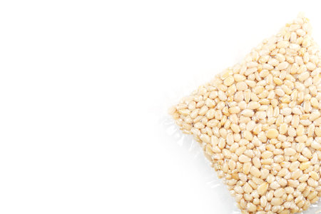Pine nuts in a transparent vacuum package over a white background