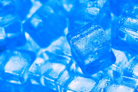 Ice made of cubes lined up with drops on a blue backgroundの写真素材