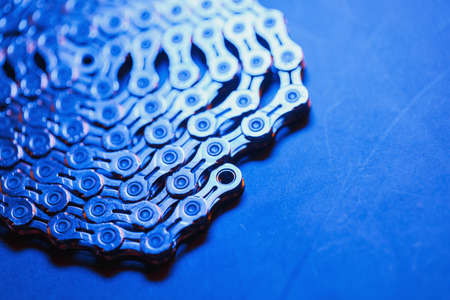 Patterns of a technological bicycle chain braided in a circle with blue-purple illuminationの写真素材