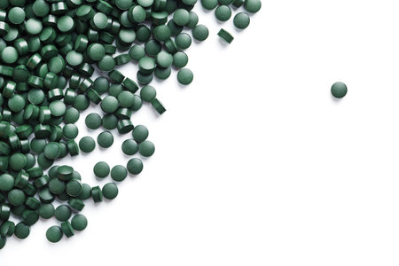 Vegetarian vitamins from Spirulina are scattered on a white background with free spaceの写真素材