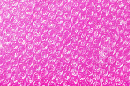 The texture of the packaging air-bubble film on a Pink background in full screen