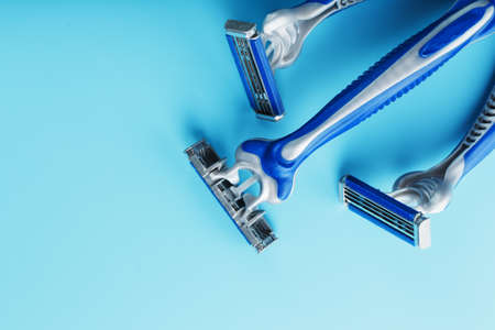 Blue shaving machine with sharp blades on the background of ice cubes close-up. The concept of cleanliness and frosty freshnessの写真素材