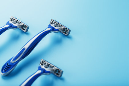 Blue shaving machine with sharp blades on the background of ice cubes close-up. The concept of cleanliness and frosty freshnessの写真素材