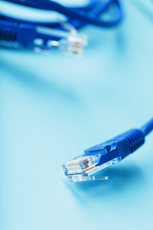 A coil of an Internet network cable for data transmission on a blue background. Patch cord for LAN...