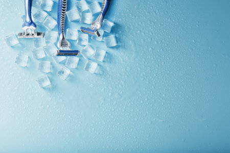Blue shaving machines in a row on a blue background with ice cubes. The concept of cleanliness and frosty freshnessの写真素材