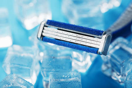 Shaving machine on a blue background with ice cubes. The concept of cleanliness and frosty freshnessの写真素材