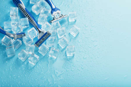 Shaving machine on a blue background with ice cubes. The concept of cleanliness and frosty freshnessの写真素材