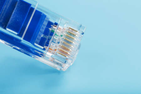 A coil of an Internet network cable for data transmission on a blue background. Patch cord for LAN cable.の写真素材