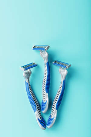 Blue shaving machine with sharp blades on the background of ice cubes close-up. The concept of cleanliness and frosty freshnessの写真素材