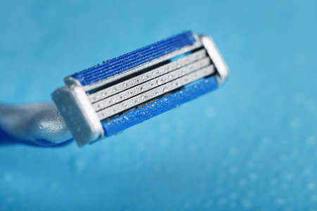 Three shaving machines on a blue background with free space, top viewの写真素材