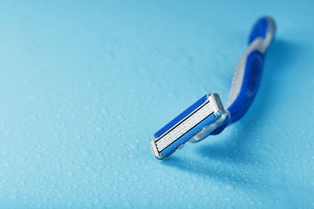 Three shaving machines on a blue background with free space, top viewの写真素材