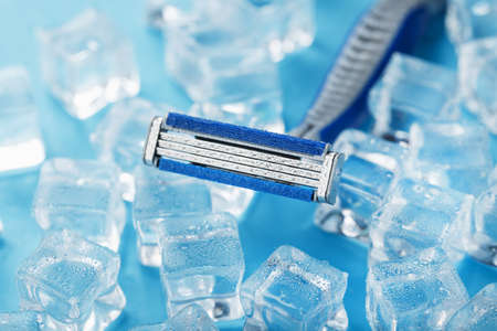 Blue shaving machines in a row on a blue background with ice cubes. The concept of cleanliness and frosty freshnessの写真素材