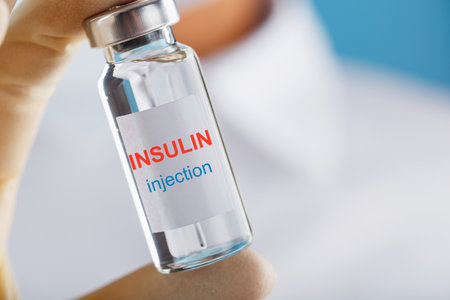 The doctor holds a syringe for injections and an ampoule with insulin for the treatment of Diabetesの写真素材