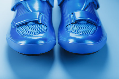Blue Shiny Bicycle Shoes for Road Bike on Blue Backgroundの写真素材