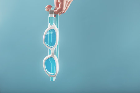 White swimming glasses with a blue lens on a blue backgroundの写真素材