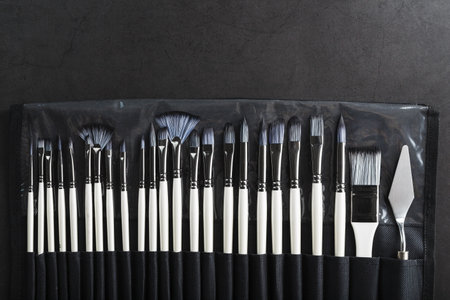 A set of art brushes for drawing on a black background, top view with free spaceの写真素材