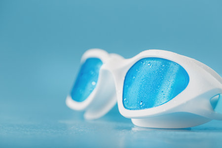 White swimming goggles on a blue background in a minimalist style with free spaceの写真素材