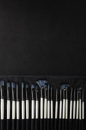 Paint tubes, brushes for painting and palette knifes on old wooden backgroundの写真素材