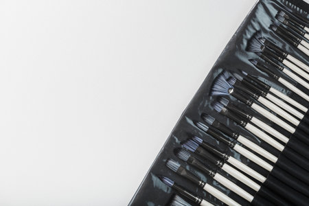 Brushes, palette knives in a pencil case on a white canvas backgroundの写真素材