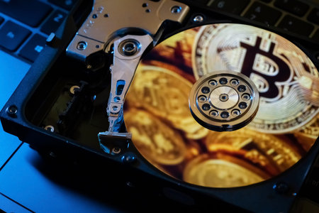Reflection of gold coins of the cryptocurrency on the hard disk