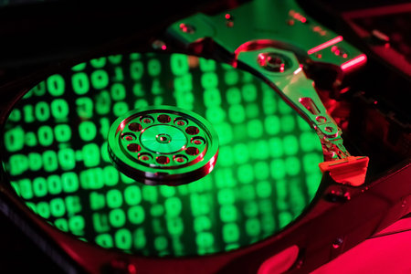 moving hard drive head with green data on drive