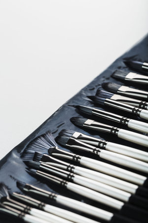 Brushes in a pencil case on a white canvas background