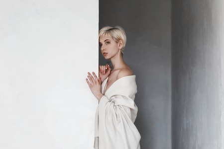 Beautiful blondie girl near white wall close-upの写真素材