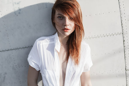 Portrait of red-haired girl close-up near the wallの写真素材