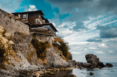 lonely old house on a rock cliff on seashoreの写真素材