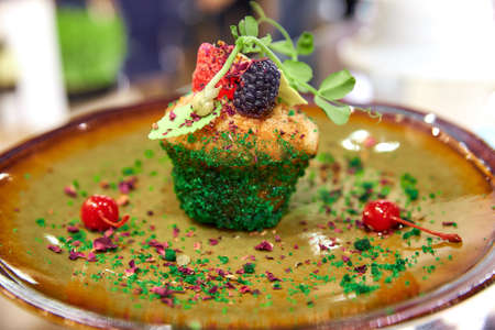 sponge cupcake decorated with blackberries raspberries and pickled cherriesの写真素材