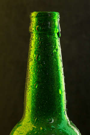 Green beer bottle with drops on black background close-upの写真素材