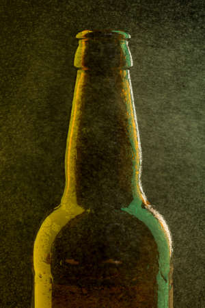 Green beer bottle with drops and green highlight on black backgroundの写真素材