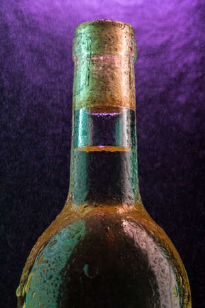 Bottle of white wine with the water droplets on violet under fine spray の写真素材
