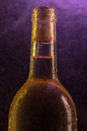 Bottle of white wine with the water droplets on violet under fine spray の写真素材