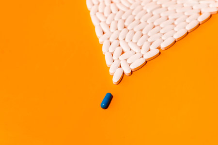 blue and white pills on orange abstract background