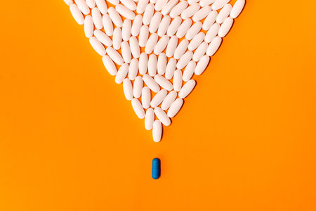 blue and white pills on orange abstract backgroundの写真素材