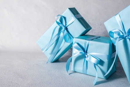 present box with blue bow isolated on gray backgroundの写真素材